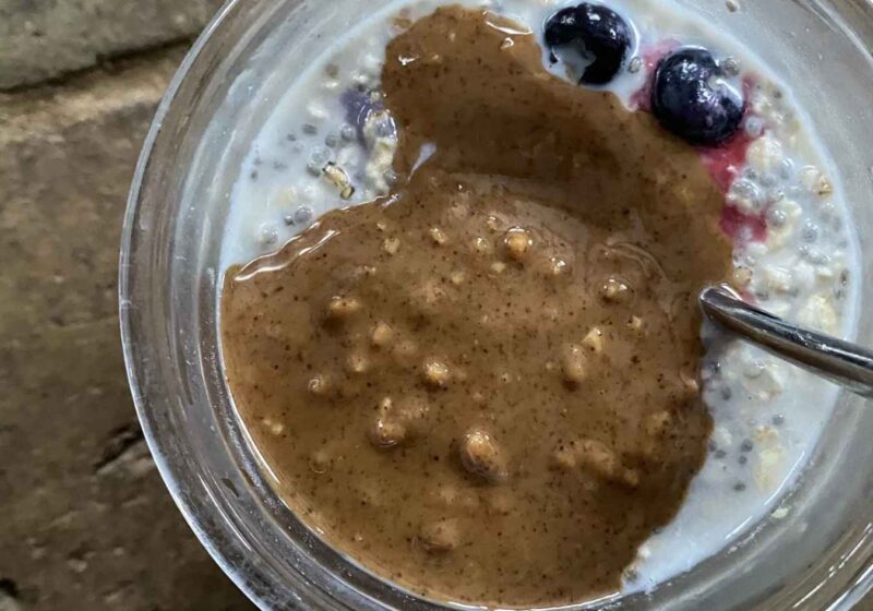 A jar of vegan chia pudding with a dollop of almond butter on top