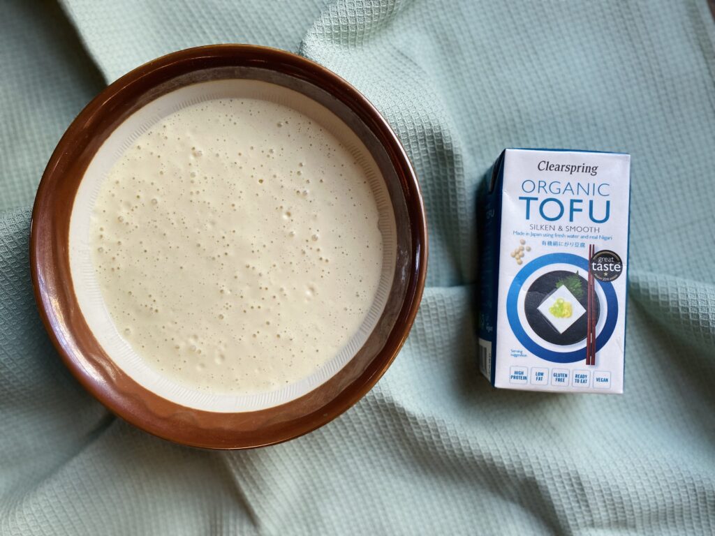 A packet of silken tofu next to a vegan silken tofu sauce base
