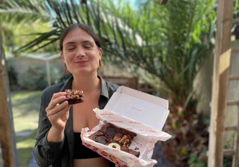 Lucy enjoying a vegan letterbox brownie from cake or death - for this cake or death review