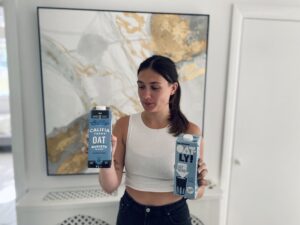 Lucy holding two different plant based milks
