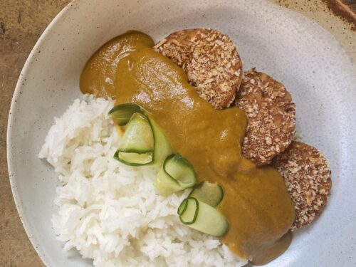 A close up of the finished vegan katsu curry recipe with breaded crispy tempeh