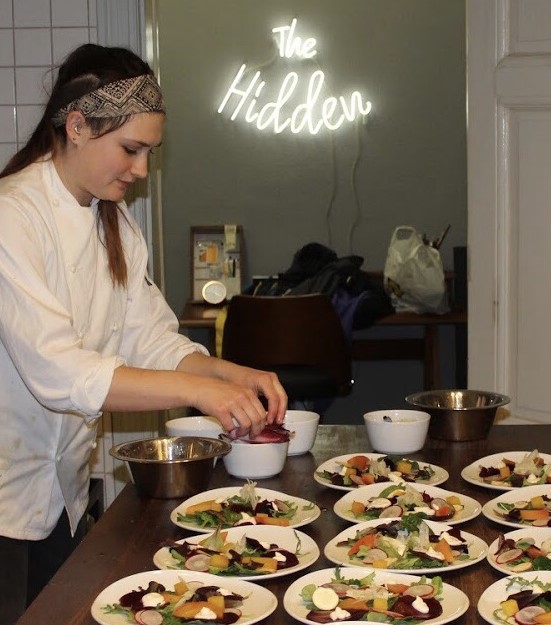 Lucy cooking at a vegan supper club
