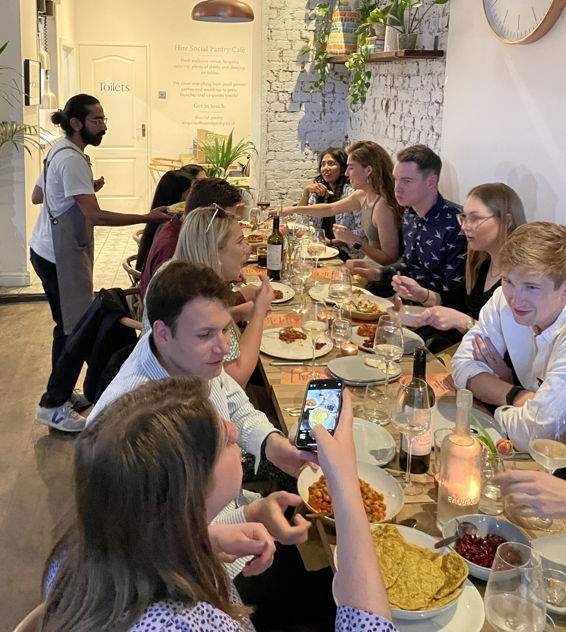 Guests sitting around a table at a vegan Indian supper club