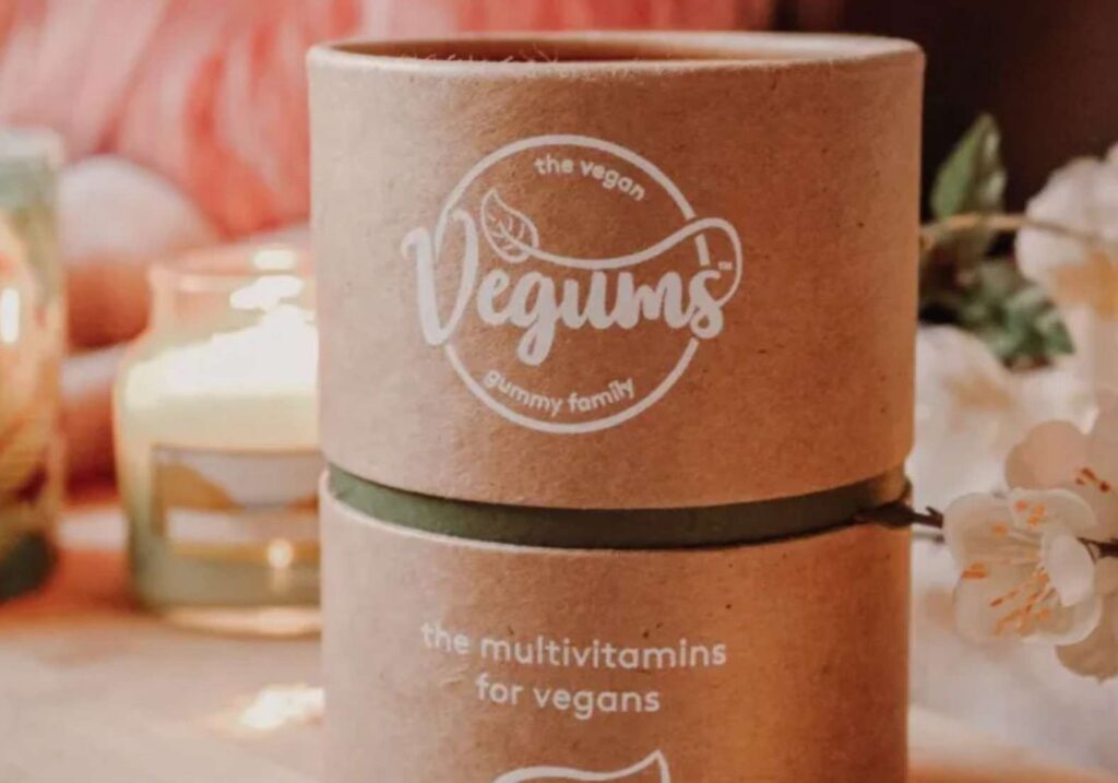 A tub of vegums multivitamins surrounded by a floral background - one of the best vegan supplement brands