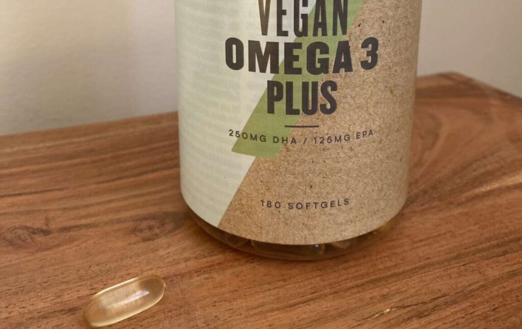 6. A tub of MYVEGAN vegan omega-3 supplements with a capsule on display