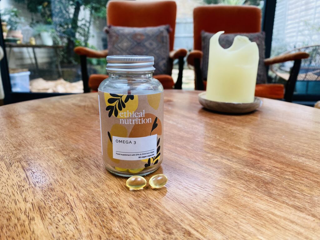 A jar of vegan omega-3 supplements from Ethical Nutrition sat on a wooden table