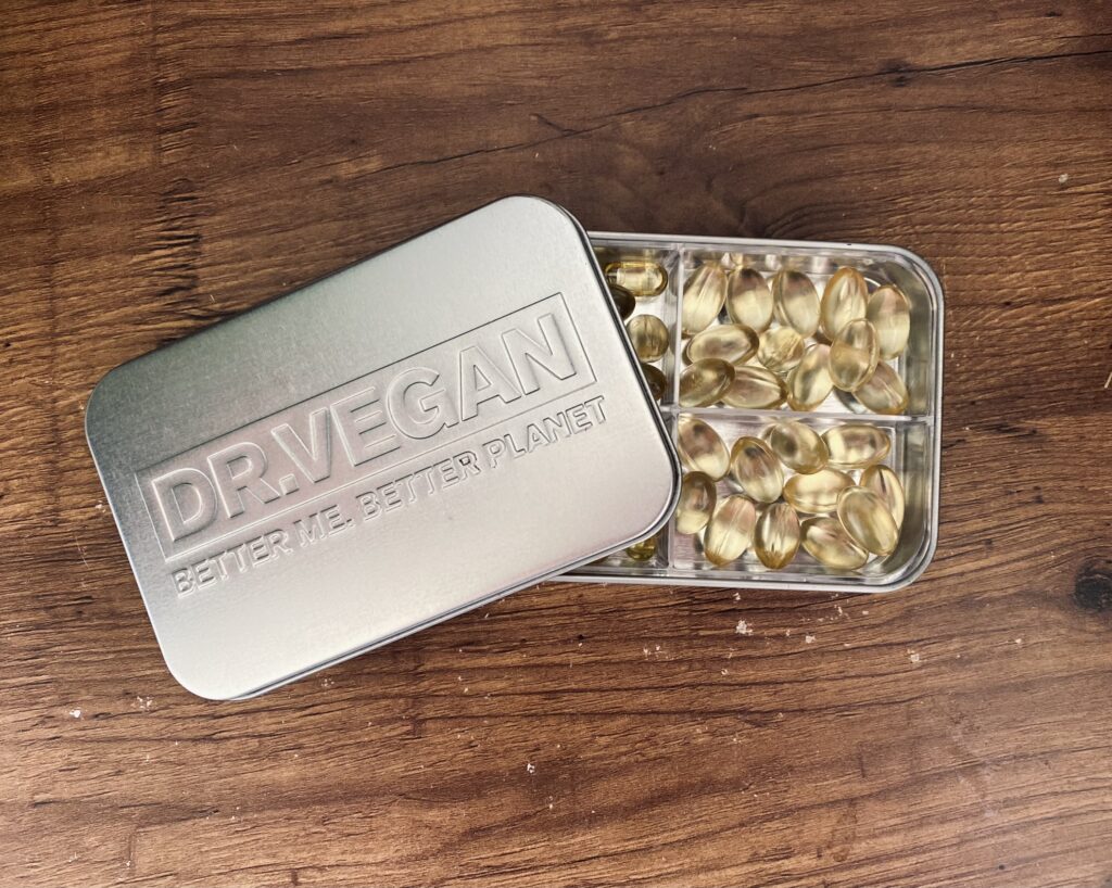 A tin of DR.VEGAN's vegan omega-3 supplements on a wooden table