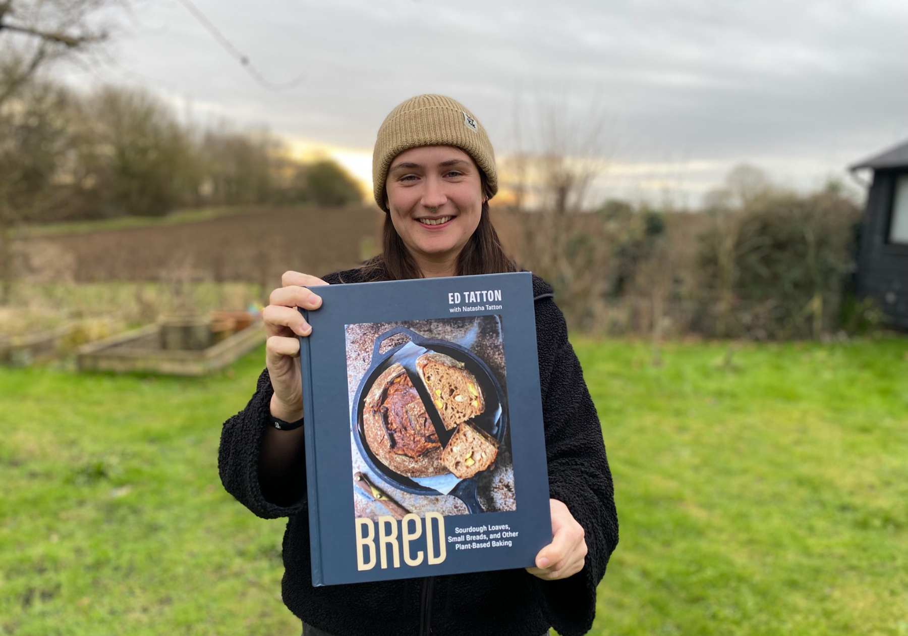 Lucy holding the BReD cookbook up to the camera
