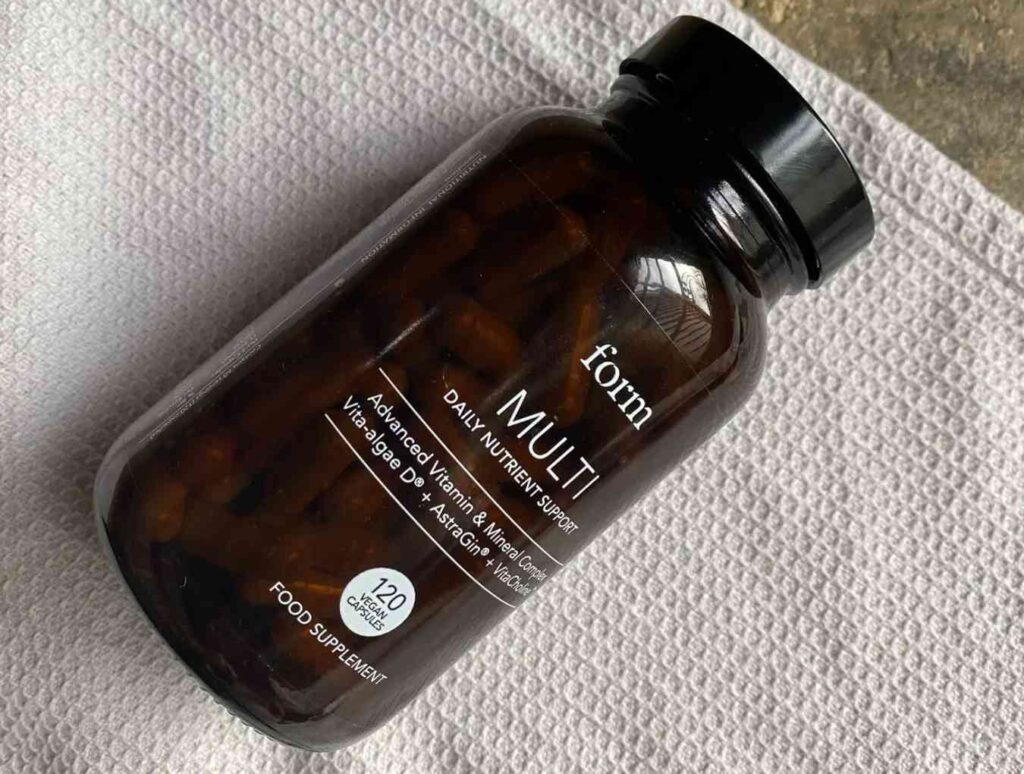 A glass jar of Form multi on top of a grey towel - one of the best vegan multivitamins
