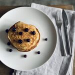 An aerial view of a stack of vegan buttermilk pancakes with blueberries scattered on top