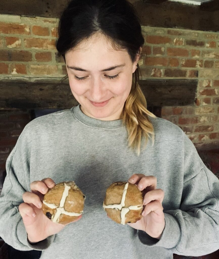 Me holding two sourdough hot cross buns