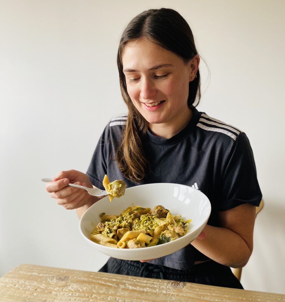 Lucy eating a vegan ready meal that is created by nutritionists