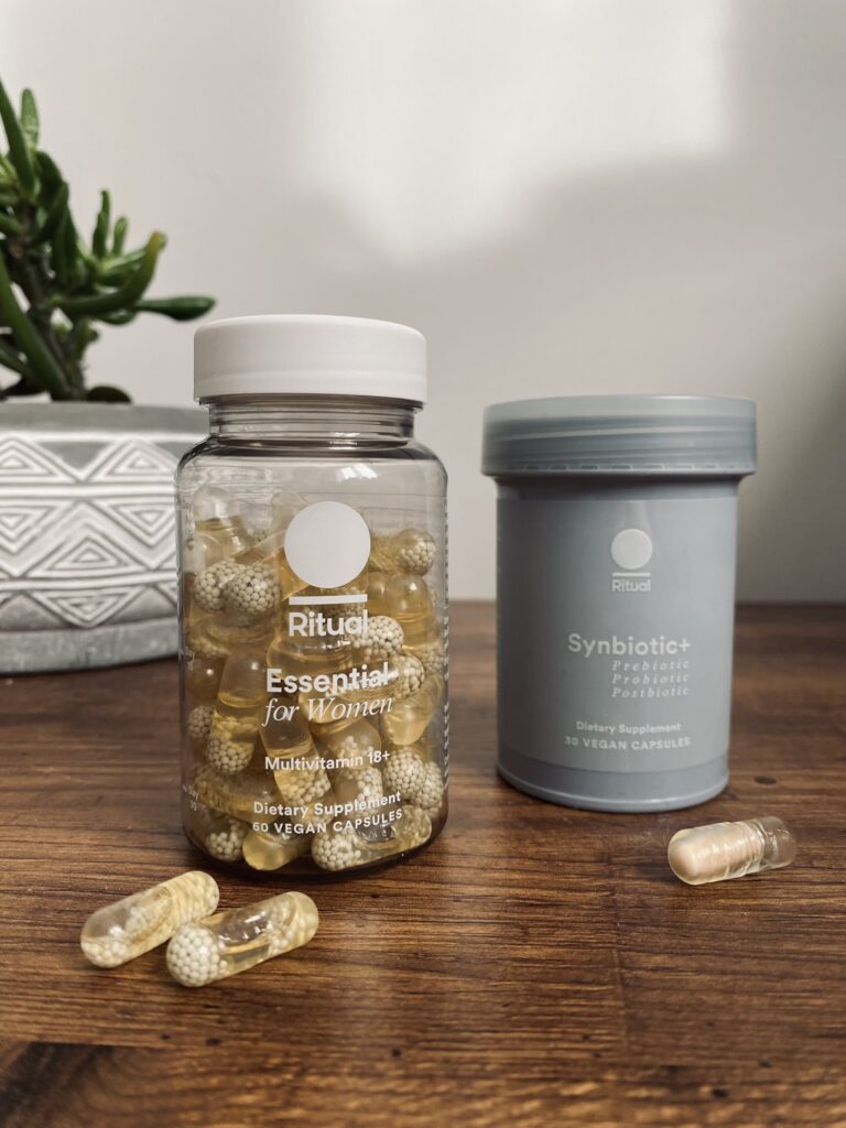 The Symbiotic and multivitamins from Ritual on top of a wooden table