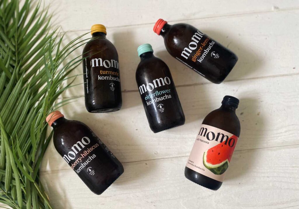 An array of the best kombucha bottles laid out on a white floor by Momo a kombucha brewery in London