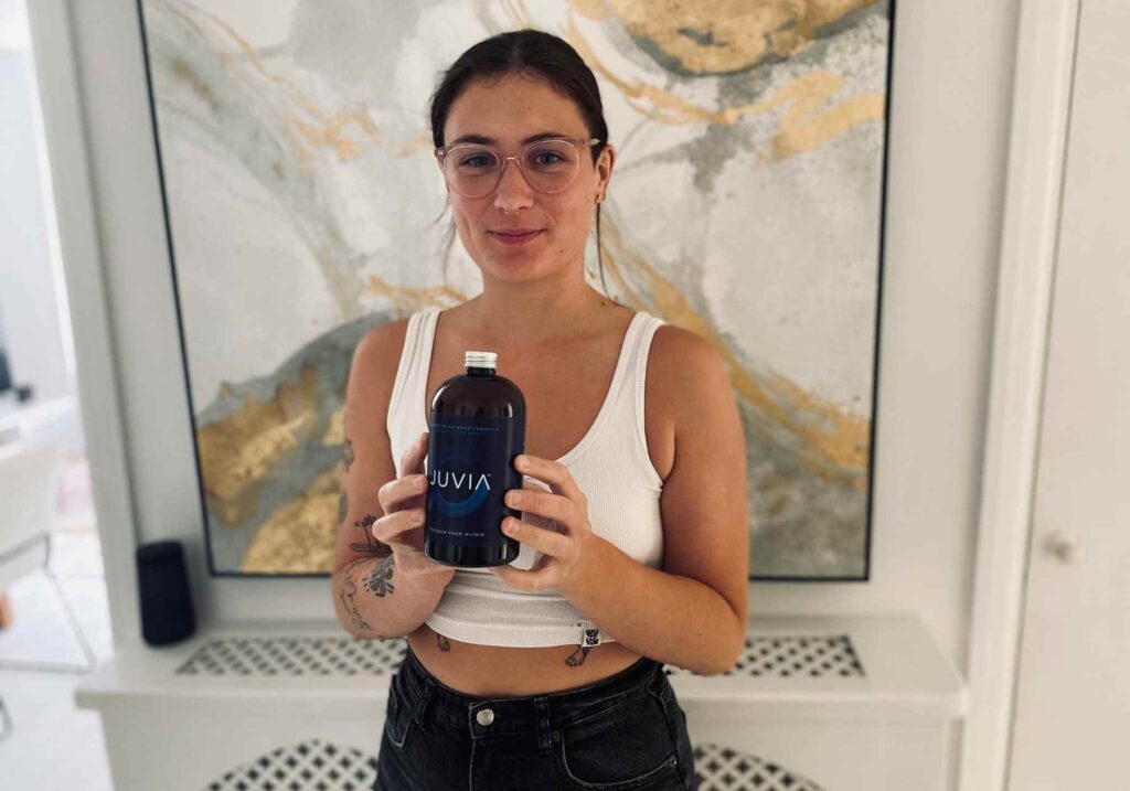 Lucy holding a bottle of Juvia gut supplement for this juvia review