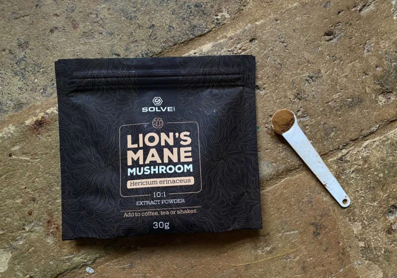 A bag of lion's mane powder next to a spoon with a serving from Solve Labs